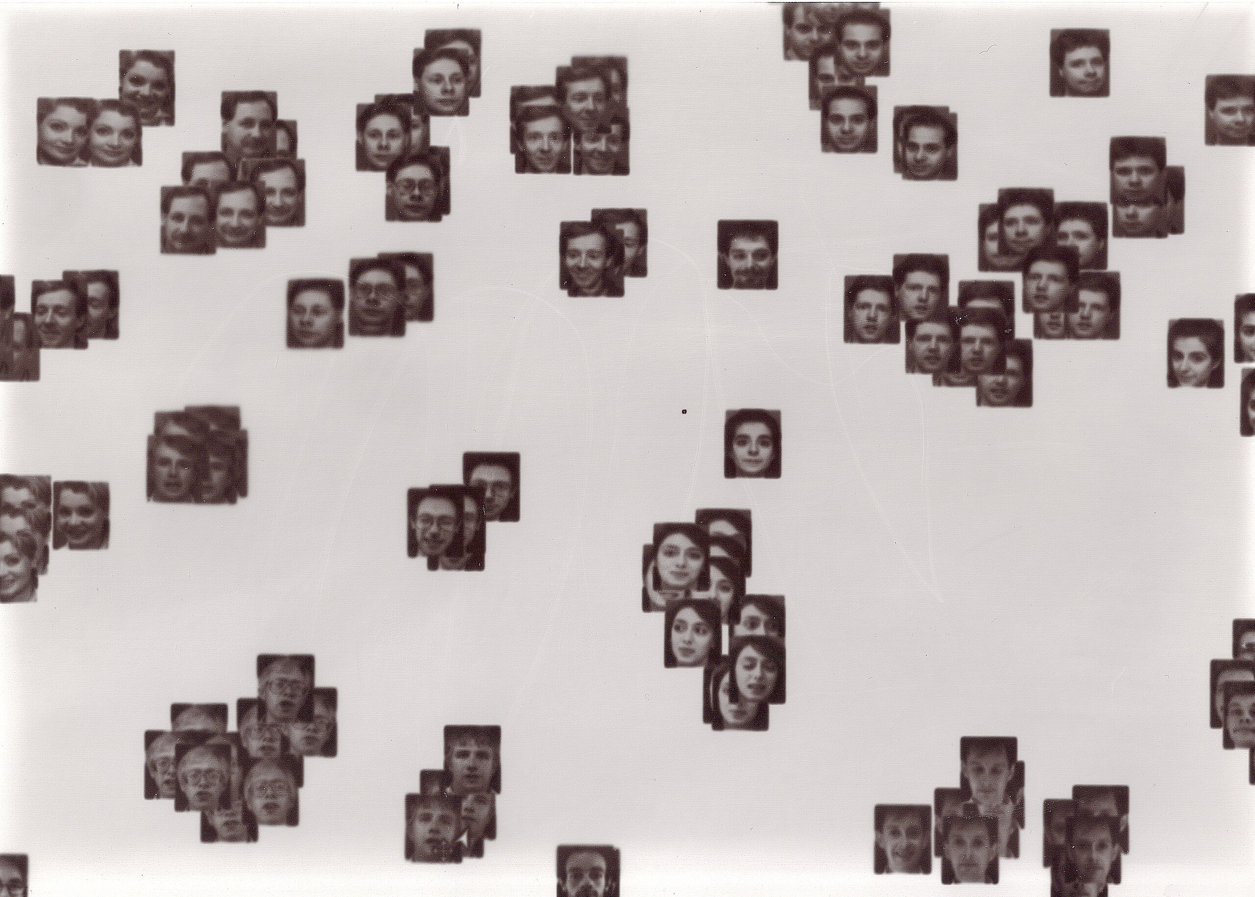 This image shows face images from the Olivetti faces dataset, created at AT&T Laboratories Cambridge in the early 1990s. The portraits are scattered across the image and grouped by similarity.